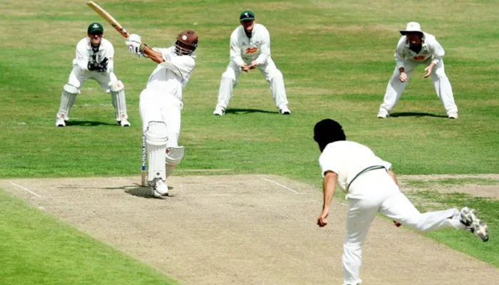 Batter playing pull shot against a bowler.