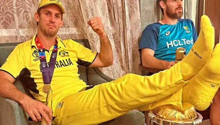 Mitchell Marsh keeping his legs on the ICC ODI World Cup Trophy.