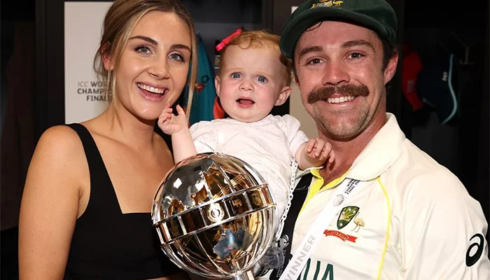 Australian star cricketer Travis Head holding ICC World Test Championship along with his wife and daughter.